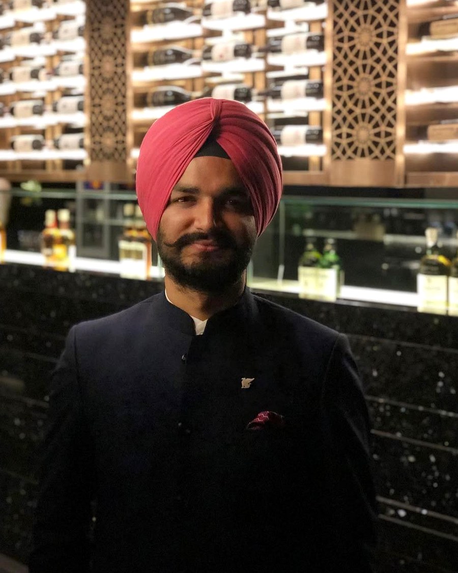 Pukhraj Bedi in front of a professionally stocked wine wall